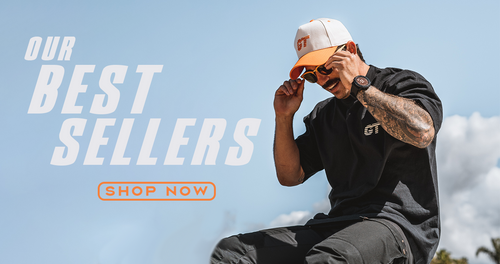 Person wearing a black t-shirt and cap with text 'Our Best Sellers' and 'Shop Now' on a blue sky background.